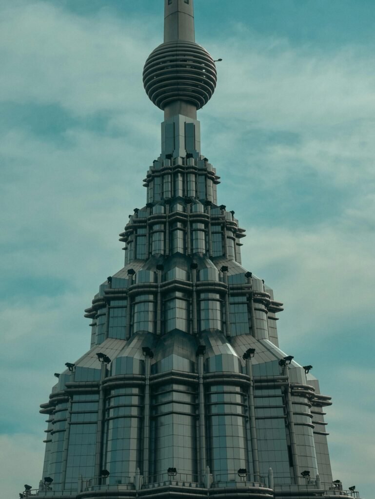 Destination Futuristic high-rise tower with layered, geometric architecture rising against a cloudy sky.