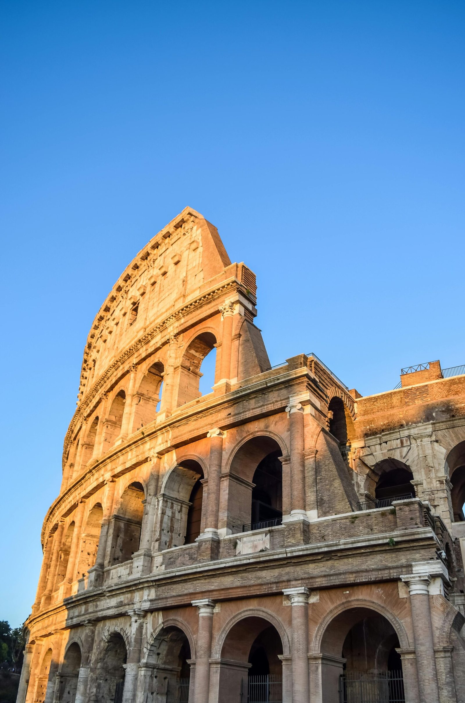 Capture of the iconic Colosseum in Rome with clear blue skies, highlighting its historic architecture.