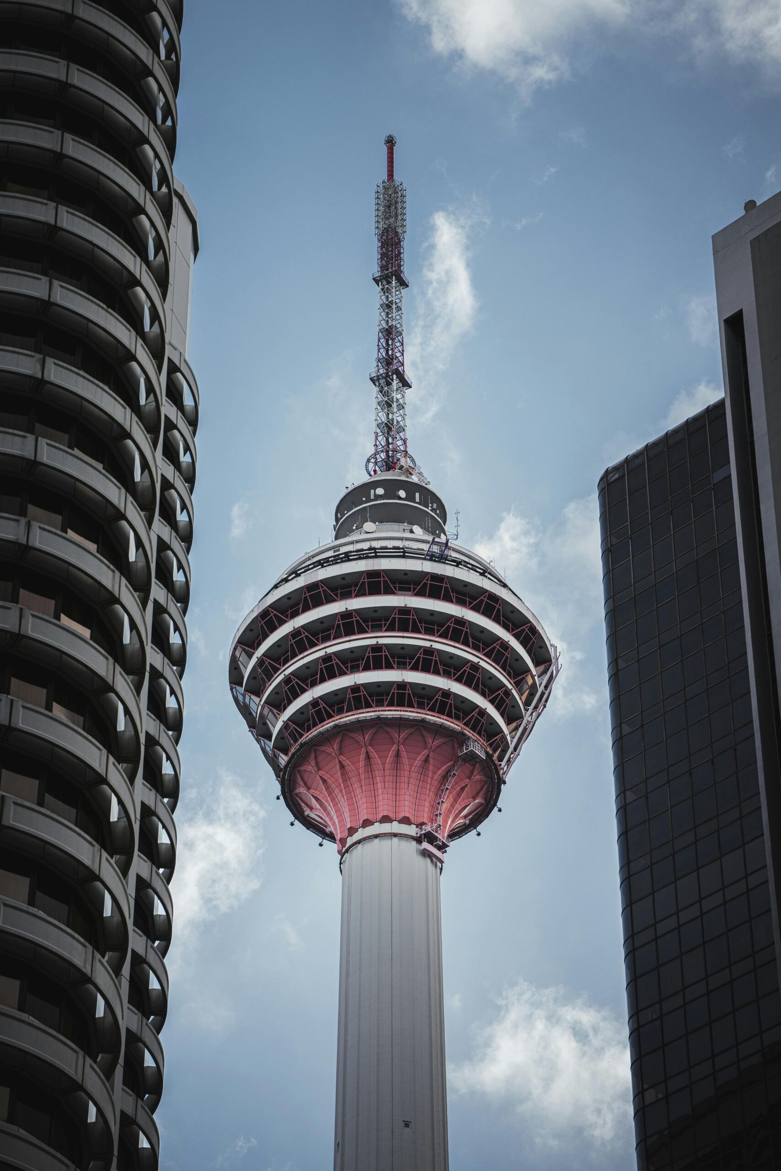 Stunning view of Menara Kuala Lumpur framed by modern buildings in Malaysia.
